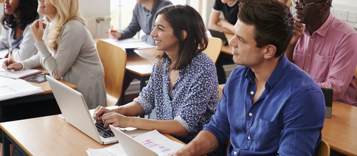 Mature Students Sitting At Desks In Adult Education Class